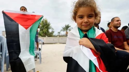 طفلة فلسطينية تحمل علم فلسطين، تعكس روح المقاومة والصمود في غزة وسط أجواء من التحدي والأمل.