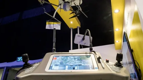 جهاز تحكم لطائرة مسيّرة من إنتاج شركة Elbit Systems، يظهر في معرض مع لافتة توضح مواصفاتها، مما يعكس استخدام الذكاء الاصطناعي في أنظمة التسليح.