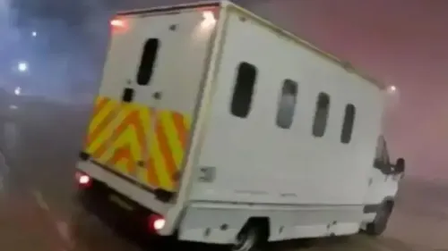 سيارة نقل محملة بالمعتقلين تتجه بسرعة في منطقة مظلمة، مع وجود أضواء ساطعة في الخلف، تعكس أجواء التوتر في قضية نشطاء العمل الفلسطيني.