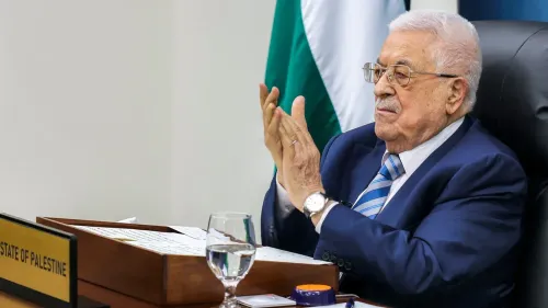 رئيس السلطة الفلسطينية محمود عباس يصفق خلال اجتماع رسمي، مع لافتة تحمل اسم "دولة فلسطين" خلفه، في سياق تعيين نائبه حسين الشيخ.