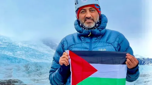 مصطفى سلامة يحمل علم فلسطين على جبل إيفرست، مرتديًا ملابس تسلق، مع خلفية جليدية، معبرًا عن أمله في دعم الأطفال في غزة.