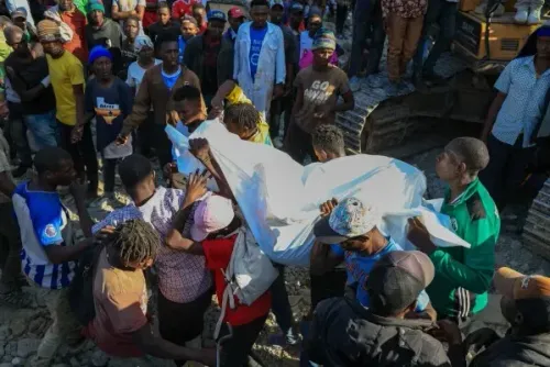 مجموعة من الأشخاص في نيروبي يحملون جثة تحت غطاء أبيض بعد انهيار مبنى أثناء عملية هدم، مما أسفر عن مقتل أربعة وإصابة آخرين.