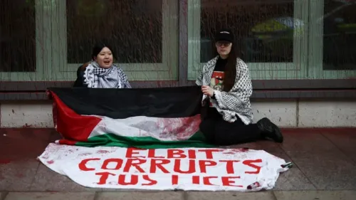 نشطاء يحملون علم فلسطين ولافتة مكتوب عليها "إلبيت تفسد العدالة" خلال احتجاج ضد شركة إلبيت سيستمز في لندن.