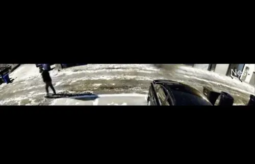 شخص مشتبه به يرتدي سترة داكنة وسروالاً فاتحاً يسير في زقاق بالقرب من منزل الزوجين تيبي في كولومبوس، أوهايو.