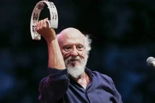 ديونيسيس سافوبولوس، المغني اليوناني الشهير، يحمل آلة الطنبور أثناء أداء موسيقي، معبرًا عن شغفه بالفن والثقافة اليونانية.