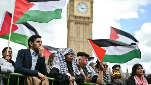 مشاركون في مسيرة تضامن مع فلسطين في لندن، يحملون الأعلام الفلسطينية، مع ساعة بيغ بن في الخلفية، تعبيراً عن دعمهم للقضية الفلسطينية.
