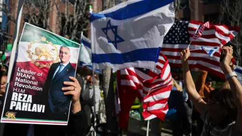 لافتة تحمل صورة رضا بهلوي، مع أعلام إسرائيل وأمريكا، خلال تجمع لدعم المعارضة الإيرانية في الشتات.
