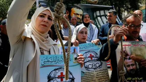 ناشطون فلسطينيون يحملون لافتات وصور المعتقلين، ويظهرون حبالًا رمزية خلال احتجاج ضد قانون الإعدام الإسرائيلي.