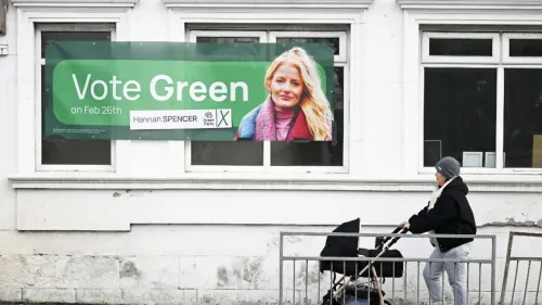 لافتة انتخابية لحزب الخضر تدعو للتصويت لصالح هانا سبنسر في انتخابات 26 فبراير، مع صورة لها خلفية خضراء.