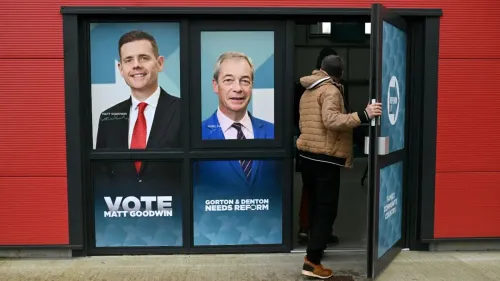 شخص يدخل مركز الاقتراع في جورتون ودينتون، مع لافتات تدعو للتصويت لمات جودوين ونايجل فاراج، وسط جدل حول "التصويت العائلي".