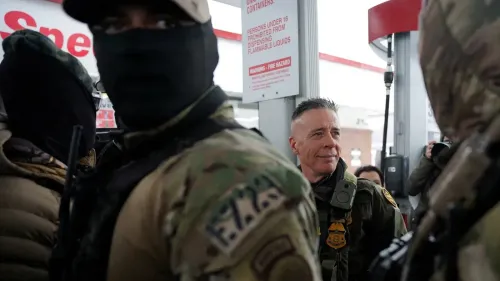 صورة لعملاء إدارة الهجرة والجمارك في مينيسوتا، يظهر فيها أحدهم مبتسمًا بينما يرتدي الآخرون أقنعة. تتعلق الصورة بعمليات الاحتجاز المستمرة للاجئين.