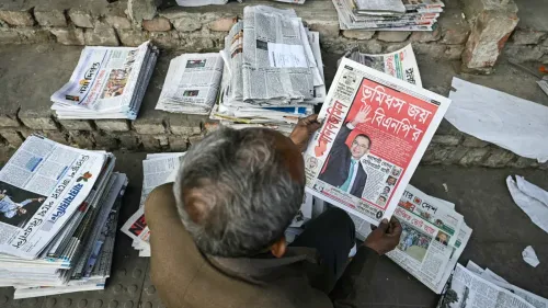 رجل مسن يجلس على درجات، ممسكًا بجريدة تحمل عنوانًا عن فوز حزب بنغلاديش القومي في الانتخابات البرلمانية، وسط أكوام من الصحف.