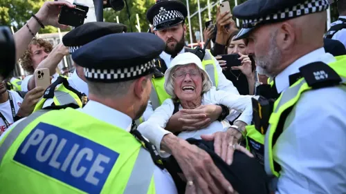 اعتقال امرأة مسنّة خلال احتجاجات ضد حظر العمل الفلسطيني في لندن، حيث تظهر تعبيرات القلق والحزن وسط تواجد الشرطة.
