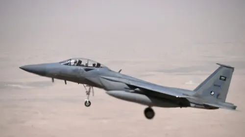 طائرة حربية من طراز F-15 سعودية تحلق في السماء، تعكس جهود المملكة في تعزيز قدراتها الدفاعية وسط مناقشات حول صفقات الأسلحة.
