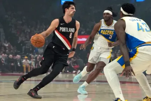 دينى أفديجا، لاعب بورتلاند تريل بليزرز، يتجاوز مدافعين من إنديانا بيسرز أثناء المباراة، مع التركيز على مهاراته في المراوغة.