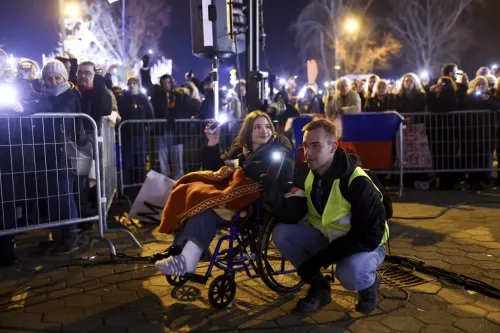 طلاب صربيون يحتجون في نوفي ساد، حيث تظهر فتاة في كرسي متحرك محاطة بأشخاص يحملون الهواتف المضيئة، تعبيرًا عن التضامن.