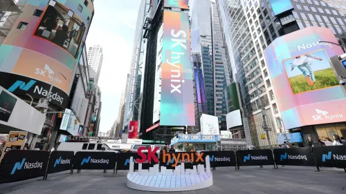 شعار SK Hynix بارز في ميدان تايمز سكوير بنيويورك مع شاشات رقمية تعلن إدراج الشركة في بورصة ناسداك، في سياق توسعها العالمي واستثماراتها في تصنيع رقائق الذاكرة.