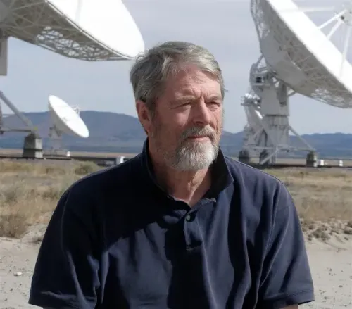 جيم سانبورن يجلس أمام محطات إرسال كبيرة، يعكس اهتمامه بعالم الجاسوسية والفن، بينما يستعد لبيع حل لغز "كريبتوس".