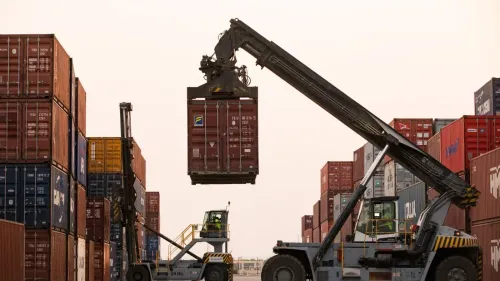 رفع رافعة حاويات في ميناء مزدحم، حيث تُظهر الصورة عمليات الشحن والتفريغ في سياق التوترات السياسية بين الصومال والإمارات.
