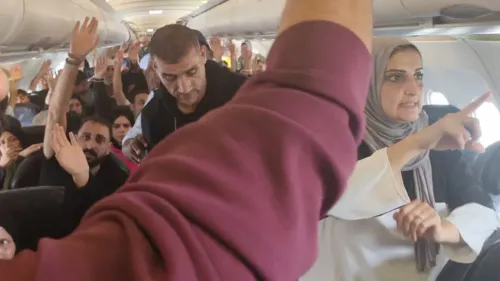 ركاب فلسطينيون في طائرة، يرفعون أيديهم في حالة من الارتباك والغضب، بعد احتجازهم في مطار جنوب أفريقيا.