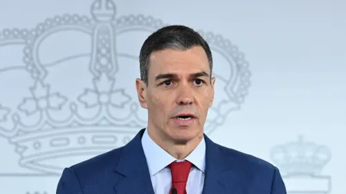 رئيس الوزراء الإسباني بيدرو سانشيز يتحدث في مؤتمر صحفي، مع خلفية تحمل رموزًا ملكية، معبرًا عن موقف إسبانيا ضد الحرب.