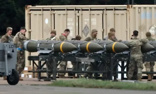 جنود يقومون بتجهيز قنابل في قاعدة عسكرية، مما يعكس تصاعد التوترات العسكرية والتهديدات بالهجمات في الشرق الأوسط.