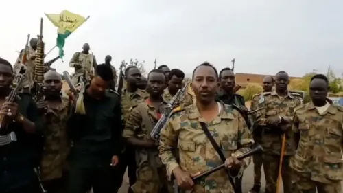 جنود من الجيش السوداني في مدينة الأبيض، يحملون أسلحة، مع علم يرمز إلى القوات. يعكس المشهد الأوضاع المتوترة في المنطقة.