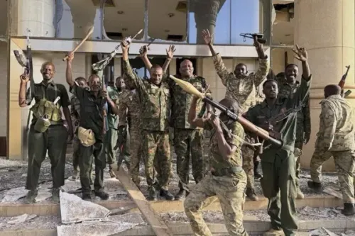 جنود سودانيون يحتفلون داخل القصر الجمهوري بعد استعادته، مع أسلحة في أيديهم، في مشهد يعكس انتصار الجيش في الصراع المستمر.