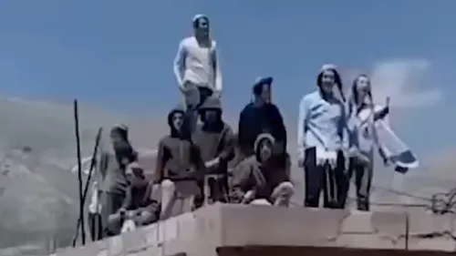 مجموعة من المستوطنين الإسرائيليين يقفون على سطح مبنى في منطقة الجولان، يحملون الأعلام الإسرائيلية ويعبرون عن رغبتهم في إقامة مستوطنة جديدة.