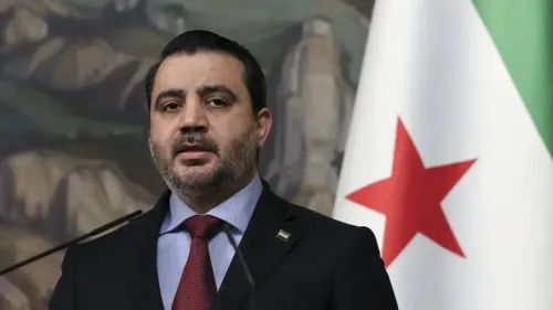 وزير الخارجية السوري أسعد الشيباني يتحدث في تشاتام هاوس بلندن، مع العلم الوطني السوري خلفه، حول مستقبل سوريا والديمقراطية.