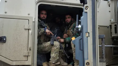 جنود يجلسون داخل مركبة عسكرية، يرتدون زيًا عسكريًا ويحملون أسلحة، في سياق تصاعد التوترات في شمال شرق سوريا.