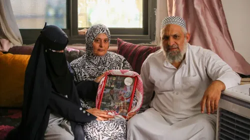 عائلة فلسطينية تجلس في منزلها تحمل صورة ابنتهم المعتقلة ندى بني عودة، تعبيراً عن الحزن والحنين لعودة التعليم والحرية.