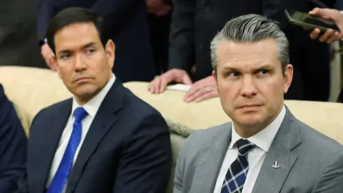 وزير الحرب الأمريكي بيتر هيغسيث ووزير الخارجية ماركو روبيو يجلسان معًا، مع تعبيرات وجه تعكس التوتر حول استراتيجية الولايات المتحدة تجاه إيران.