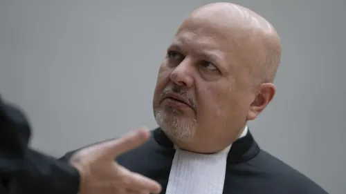 كاريم خان، المدعي العام للمحكمة الجنائية الدولية، يرتدي الزي الرسمي ويتلقى حديثاً جاداً، في سياق تصويت محتمل على إقالته بسبب قضايا سياسية وقانونية.