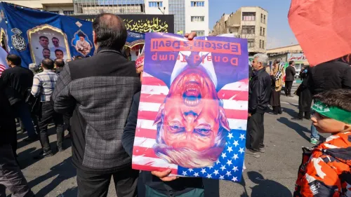 محتجون إيرانيون يحملون لافتة مقلوبة تحمل صورة للرئيس الأمريكي السابق دونالد ترامب، تعبيرًا عن رفضهم للسياسات الأمريكية.