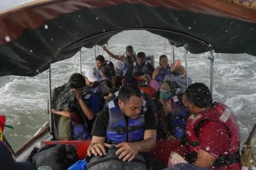 مجموعة من المهاجرين في قارب سريع يجتاز الأنهار الكثيفة بين كولومبيا وبنما، يتشبثون بحقائبهم ويحتمون من رذاذ الماء.
