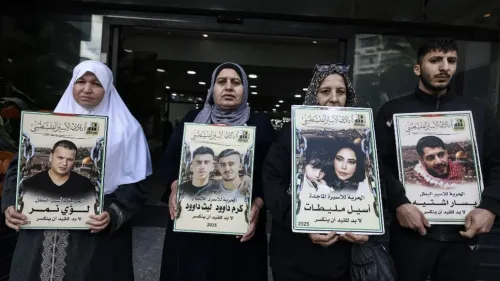 نساء ورجال يحملون لافتات تحمل صورًا لأحبائهم الذين فقدوا، في وقفة احتجاجية تعبر عن الألم والمعاناة في سياق الصراع الفلسطيني الإسرائيلي.