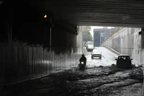 مياه الفيضانات تغمر نفقًا في مكسيكو سيتي، مع ظهور دراجة نارية وسيارات تواجه صعوبة في المرور، مما يعكس تأثير الأمطار الغزيرة على المدينة.