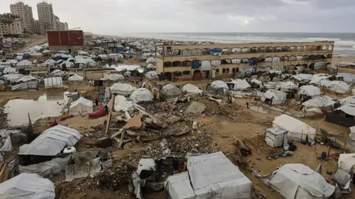 مشهد لمدينة غزة يظهر خيامًا مدمرة ومنازل مهدمة على الساحل، مما يعكس آثار الصراع المستمر والدمار في المنطقة.