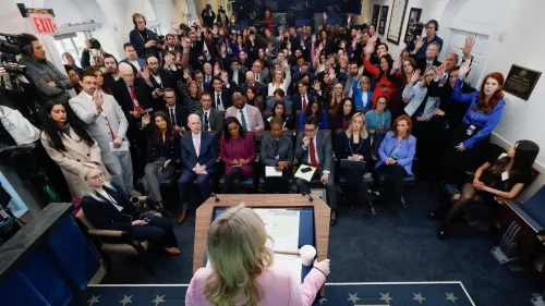 مؤتمر صحفي في البيت الأبيض حيث تتحدث السكرتيرة الصحفية كارولين ليفيت، بينما يرفع الصحفيون أيديهم لطرح الأسئلة.