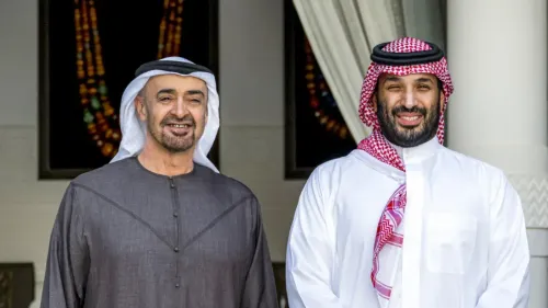 محمد بن زايد وولي العهد السعودي محمد بن سلمان يبتسمان خلال لقاء رسمي، مع خلفية تعكس العلاقات بين الإمارات والسعودية.