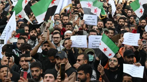 محتجون في سوريا يحملون لافتات وأعلامًا، يعبرون عن مطالبهم في تجمع حاشد لدعم الحرية والتغيير.