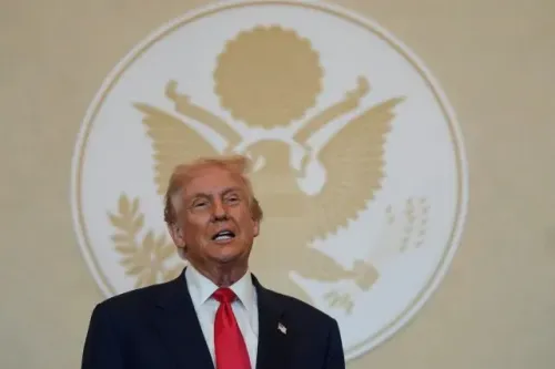 دونالد ترامب يتحدث في مؤتمر صحفي، خلفه شعار الرئاسة الأمريكية، مع التركيز على قضيته القانونية المتعلقة برشوة ستورمي دانيالز.