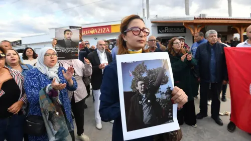 مظاهرة في تونس تضم محتجين يحملون لافتات وصورًا لسياسيين معارضين، تعبيرًا عن دعمهم لحقوق الإنسان والحريات.