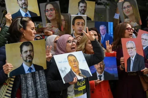 تجمع حاشد في تونس يضم متظاهرين يحملون صور شخصيات سياسية معارضة، تعبيرًا عن رفضهم للمحاكمة المرتبطة بالتآمر ضد الدولة.