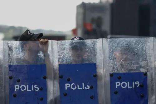 رجال شرطة يرتدون خوذات ويحتمون خلف دروع واقية مكتوب عليها "بوليس"، خلال عملية أمنية في إسطنبول.