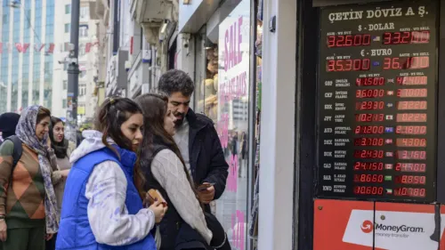 سكان يتفقدون أسعار صرف العملات الأجنبية في واجهة متجر بتركيا، حيث تظهر الأسعار المرتفعة للدولار واليورو وسط أزمة اقتصادية متزايدة.