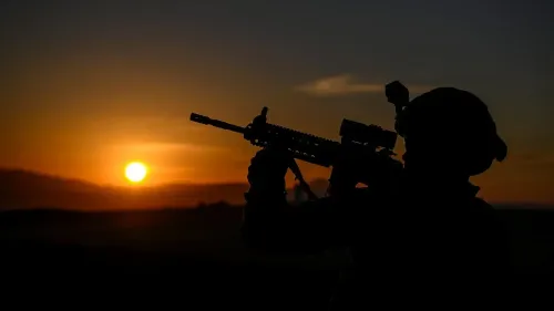 جندي يحمل سلاحه أمام شمس الغروب، في سياق التحضيرات التركية لنشر قوات حفظ سلام في غزة.