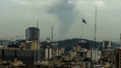 دخان يتصاعد من خلف مباني طهران، مع العلم الإيراني يرفرف في المقدمة، مما يعكس التوترات في المنطقة والجهود الدبلوماسية لإنهاء النزاع.