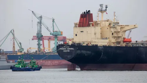 سفينة شحن كبيرة تُدعى "PHOENIX ADMIRAL" راسية في ميناء تركي، مع قوارب صغيرة تعمل على توصيلها، تعكس أنشطة التجارة البحرية.